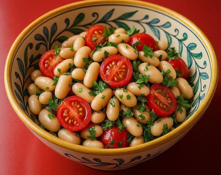 Toskanischer Bohnensalat mit weißen Bohnen, roten Kirschtomaten und frischen Kräutern dekorativ in einer Schüssel.