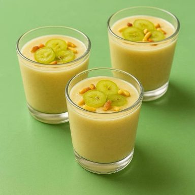 Spanische Ajoblanco Traditionelle andalusische Ajoblanco in einer weißen Schale, garniert mit halbierten hellen Trauben und goldgelb gerösteten Mandelblättchen.