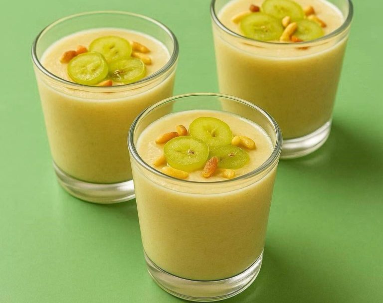 Spanische Ajoblanco Traditionelle andalusische Ajoblanco in einer weißen Schale, garniert mit halbierten hellen Trauben und goldgelb gerösteten Mandelblättchen.